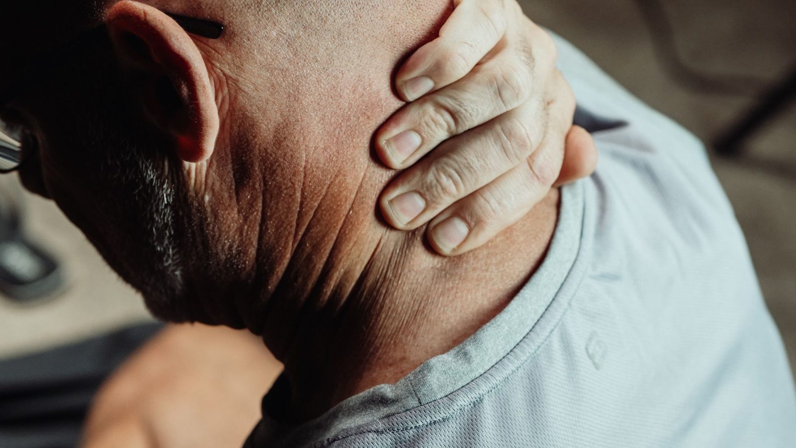 Person holding their neck in pain after an injury